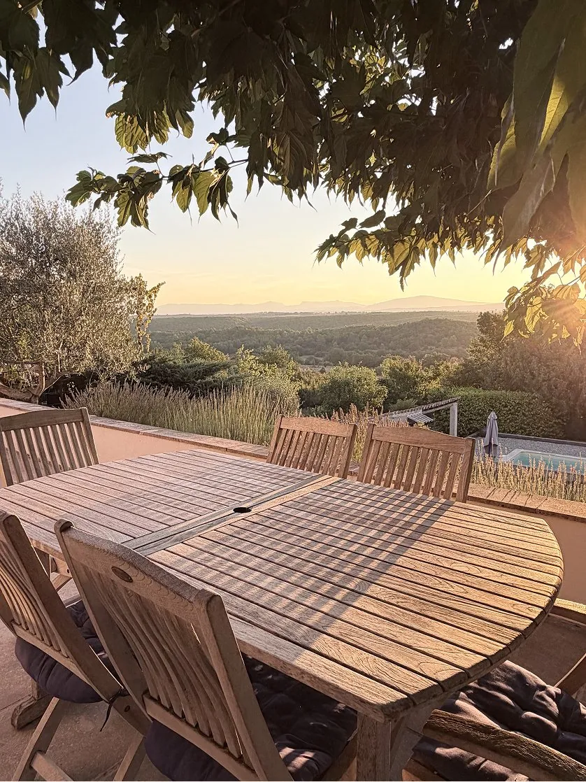 La grande table en bois face au couchant, la piscine en contrebas